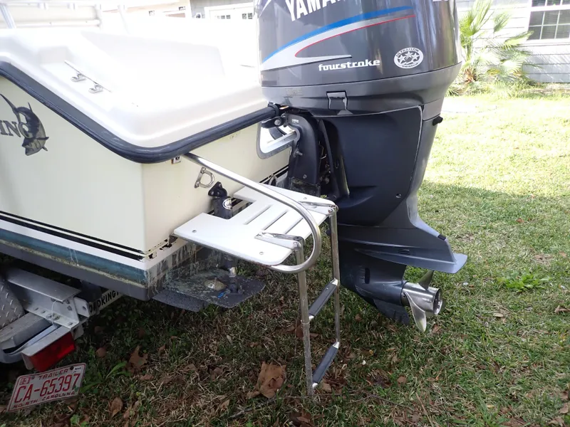 Slide: The Image of 2006 Sea King 210CC boat with Yamaha outboard motor and ladder on grassy area. - 13