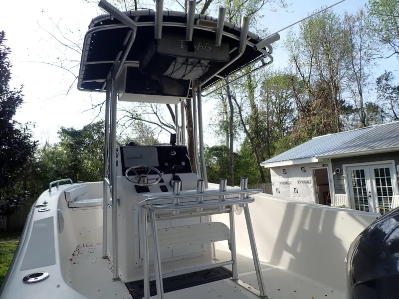 Slide: The Image of 2006 Sea King 210CC boat with center console, docked outdoors near trees and a house. - 5