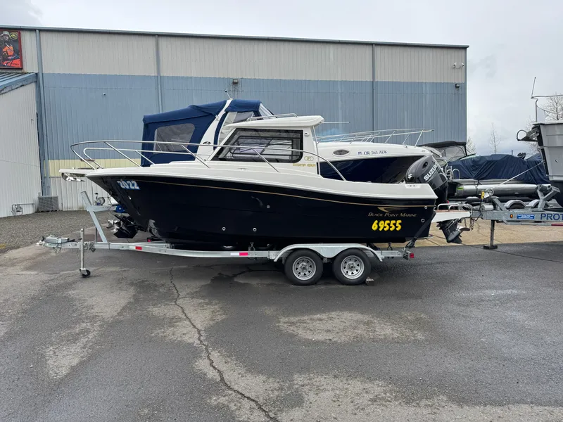The Image of 2022 Oceania 23WA boat on trailer, parked outside a warehouse. - 1