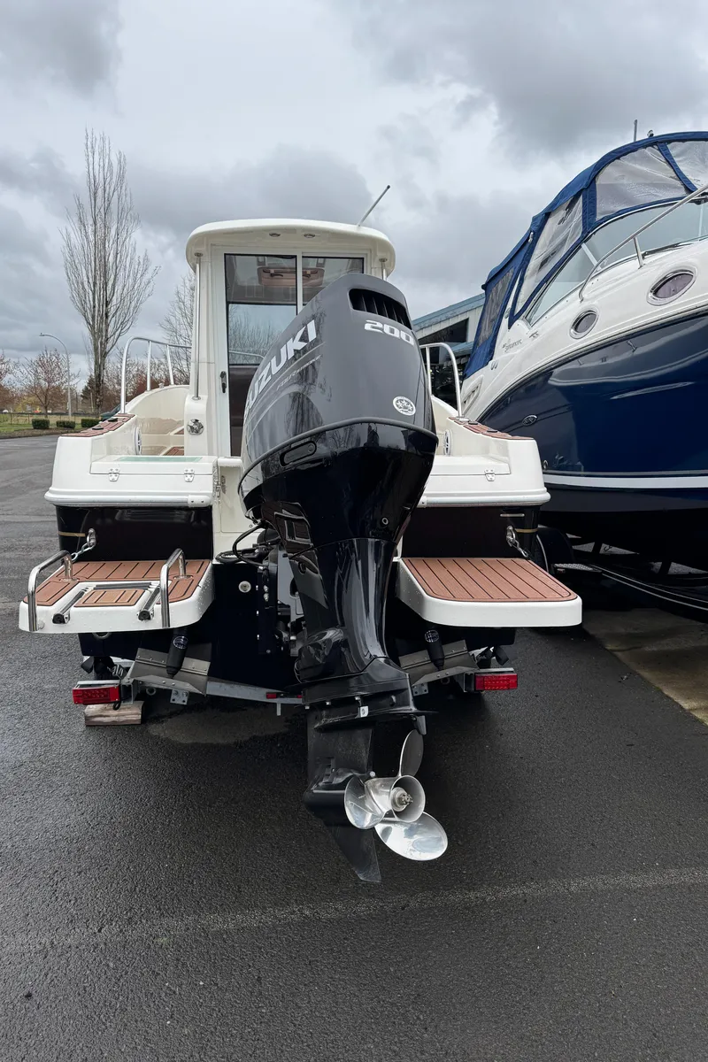 Slide: The Image of 2022 Oceania 23WA boat with Suzuki outboard motor, parked on wet pavement. - 10