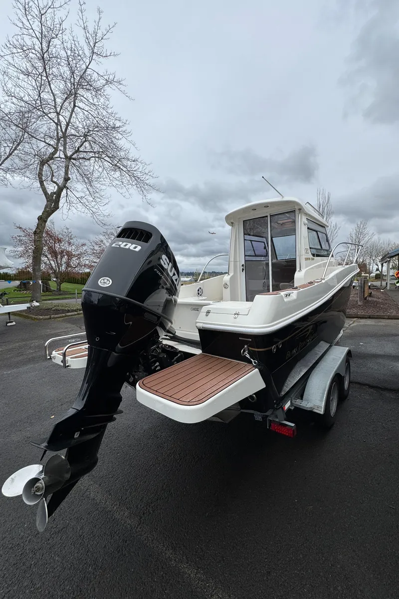 Slide: The Image of 2022 Oceania 23WA boat on trailer, featuring powerful outboard motor, parked outdoors. - 11