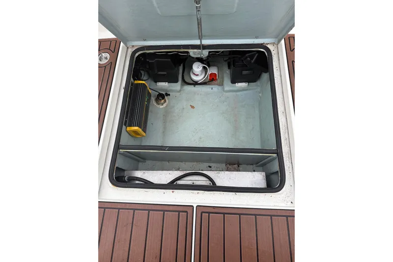 Slide: The Image of Open storage compartment on 2022 Oceania 23WA boat, featuring equipment and wooden deck. - 13