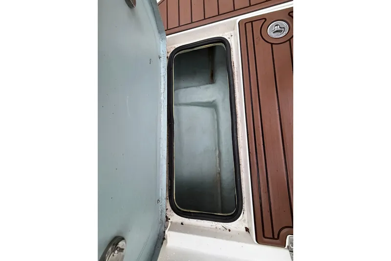 Slide: The Image of Open storage compartment on 2022 Oceania 23WA boat with brown deck panels. - 14