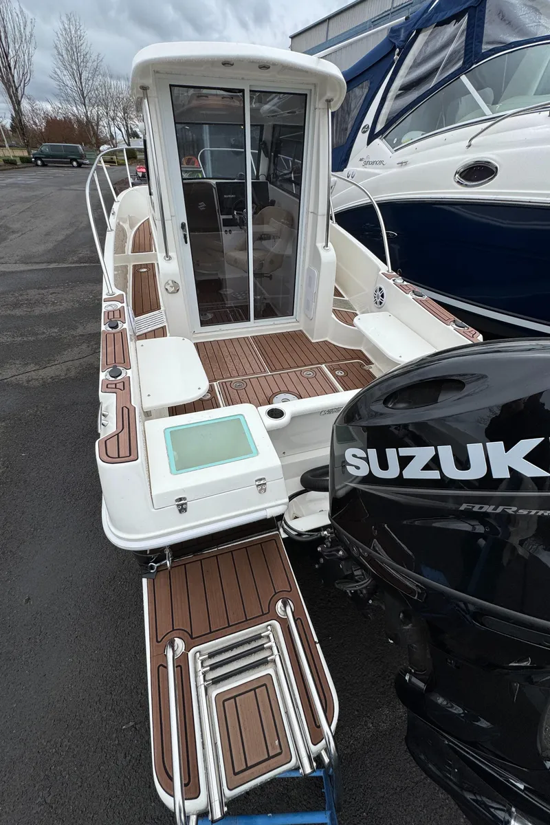 Slide: The Image of 2022 Oceania 23WA boat with Suzuki outboard motor, docked on a cloudy day. - 3