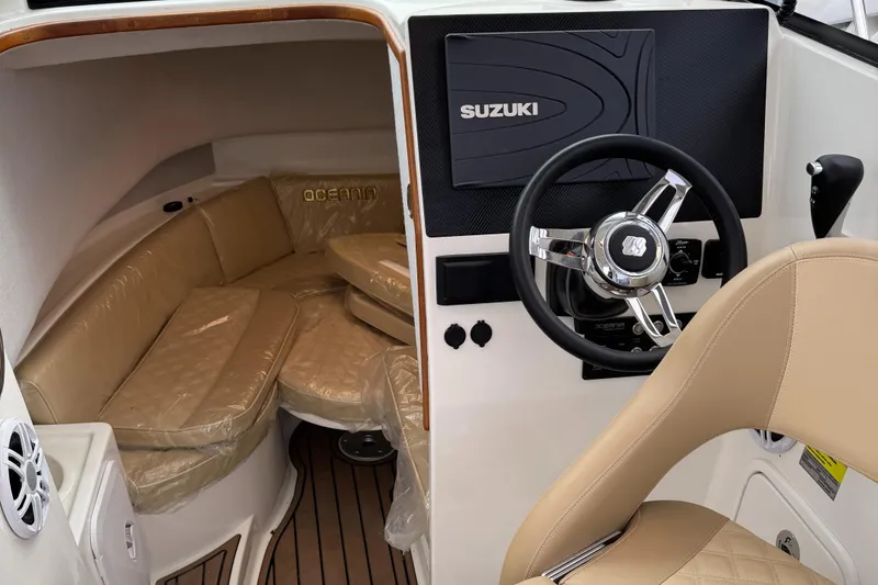 Slide: The Image of Interior of 2022 Oceania 23WA boat with Suzuki steering, beige seating, and wood flooring. - 6