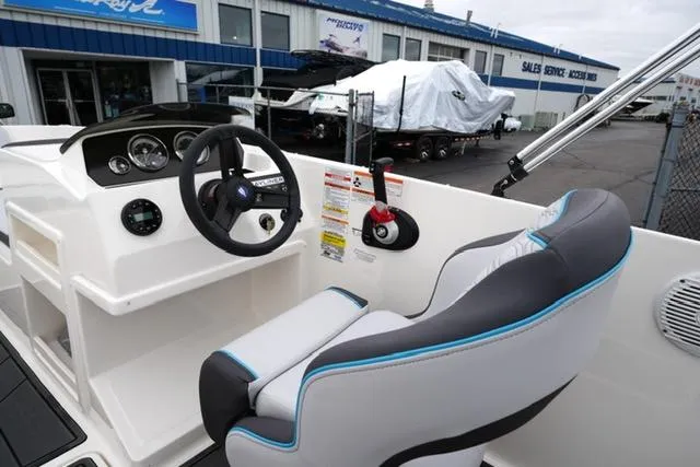 Slide: The Image of 2025 Bayliner Element M19 boat interior with steering wheel and captain's seat at dealership. - 10