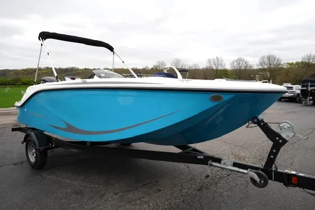 Slide: The Image of 2025 Bayliner Element M19 boat on trailer, blue hull, parked outdoors. - 2