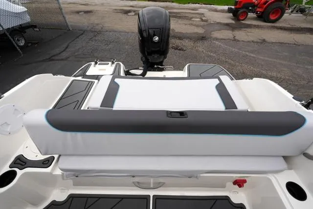 Slide: The Image of 2025 Bayliner Element M19 boat interior with cushioned seating and outboard motor. - 23