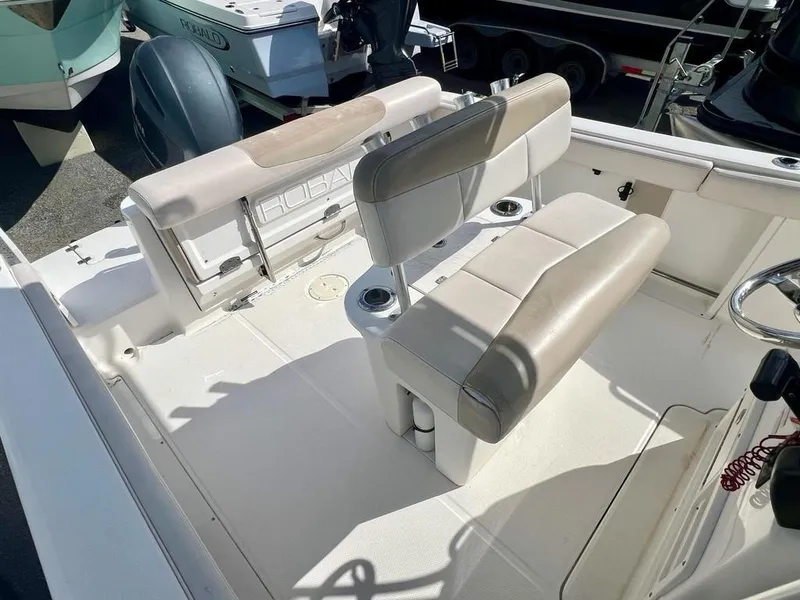 Slide: The Image of 2018 Robalo R302 boat interior with beige seating and steering wheel. - 14