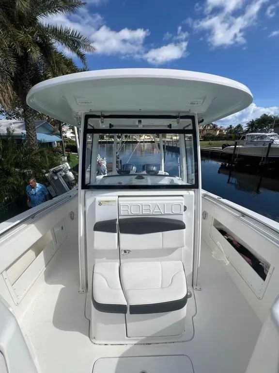 Slide: The Image of 2018 Robalo R302 boat with seating, docked near palm trees and waterway. - 9