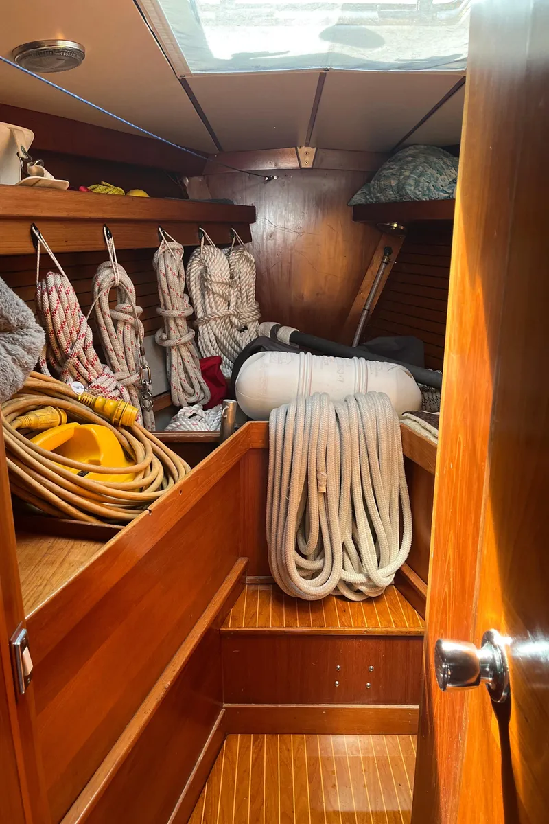 Slide: The Image of Interior of 1982 Baltic 42 sailboat with neatly stored ropes and wooden finish. - 23