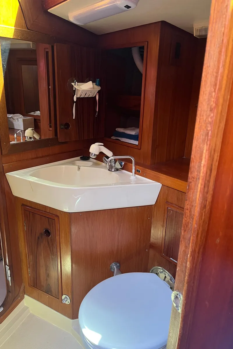Slide: The Image of Wooden bathroom interior of a 1982 Baltic 42 yacht with sink and toilet. - 48