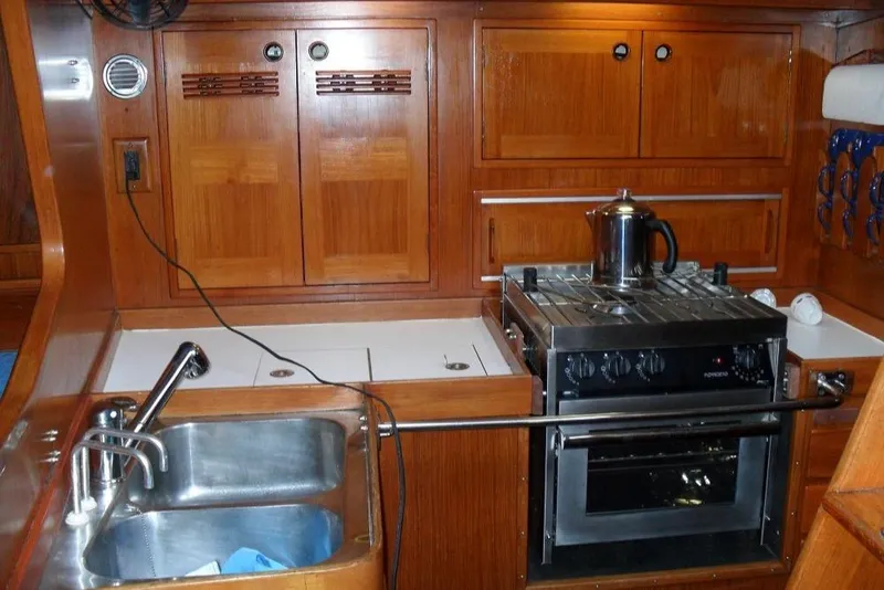 Slide: The Image of Galley kitchen in 1982 Baltic 42 yacht with wooden cabinets and stainless steel appliances. - 13