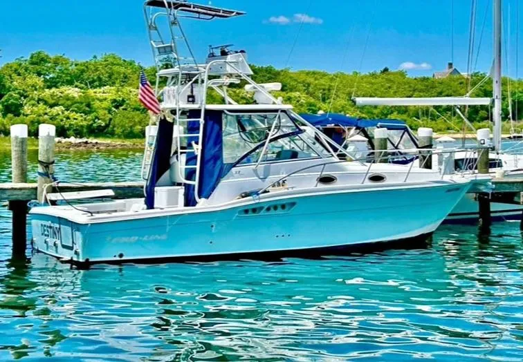 Slide: The Image of 2005 Pro-Line 33 Express boat docked in clear blue water, surrounded by lush greenery. - 1