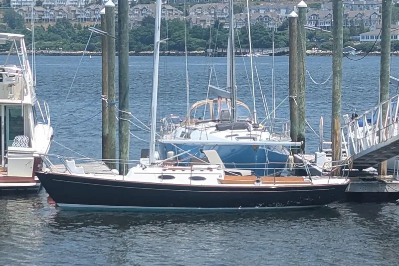 The Image of Alerion Express 28 sailboat docked at marina, 1992 model, with scenic waterfront background. - 0