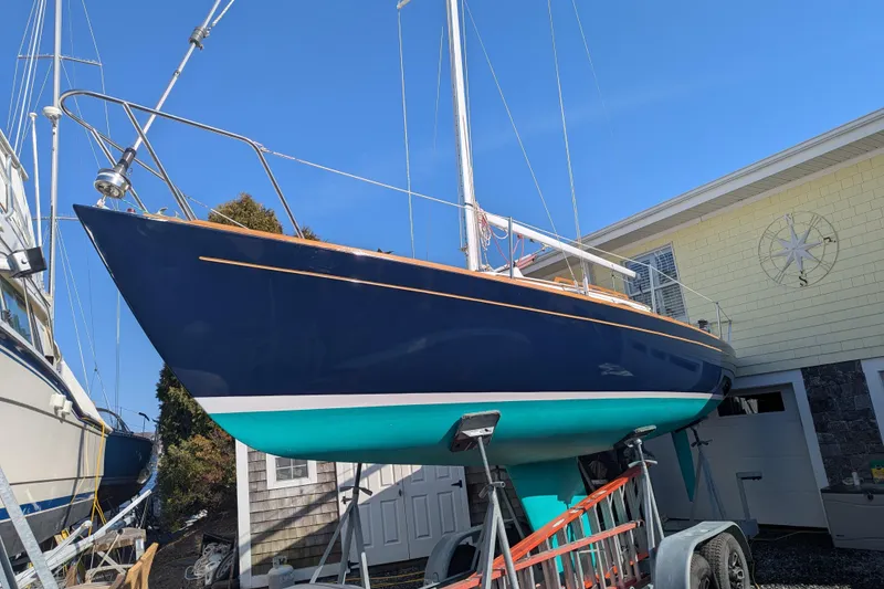 Slide: The Image of Alerion Express 28 sailboat, 2012 model, on a trailer beside a building. - 5