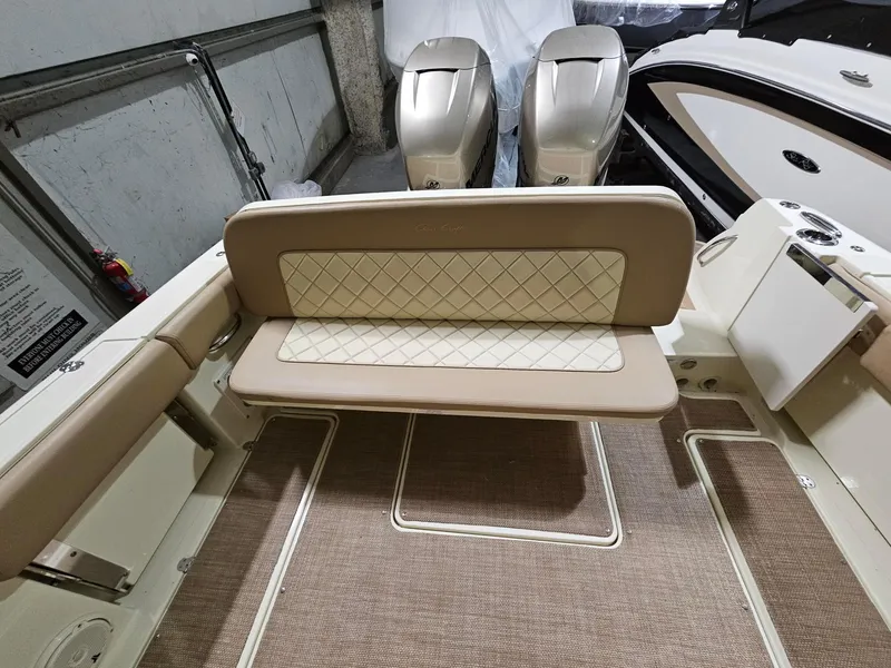 Slide: The Image of 2018 Chris-Craft 30 Catalina boat interior with beige seating and twin outboard engines. - 12