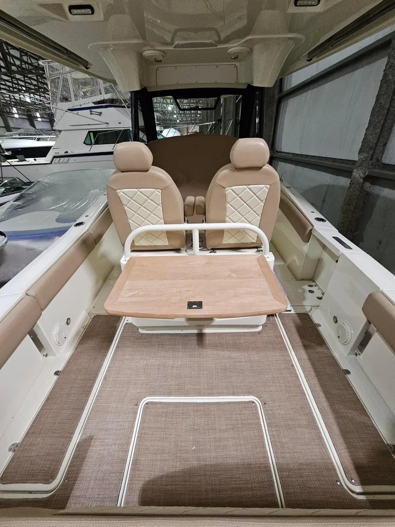 Slide: The Image of 2018 Chris-Craft 30 Catalina interior with beige seating and wooden table. - 13