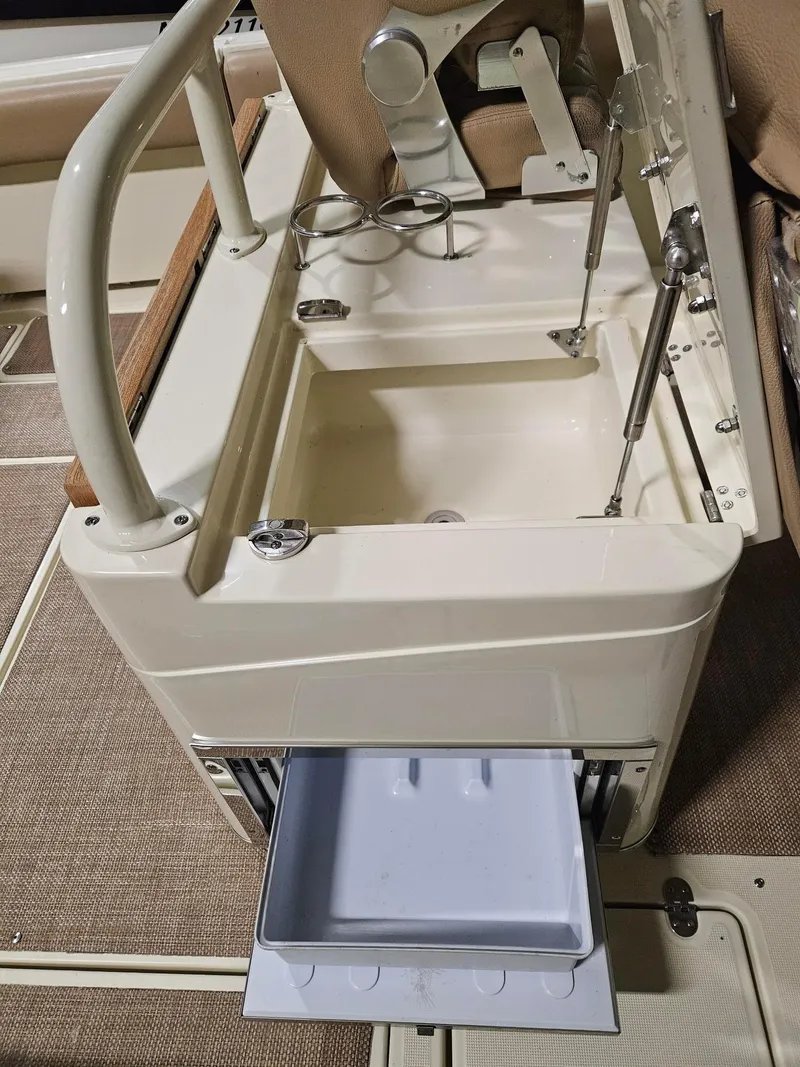 Slide: The Image of 2018 Chris-Craft 30 Catalina boat interior with open storage compartment and cup holders. - 14