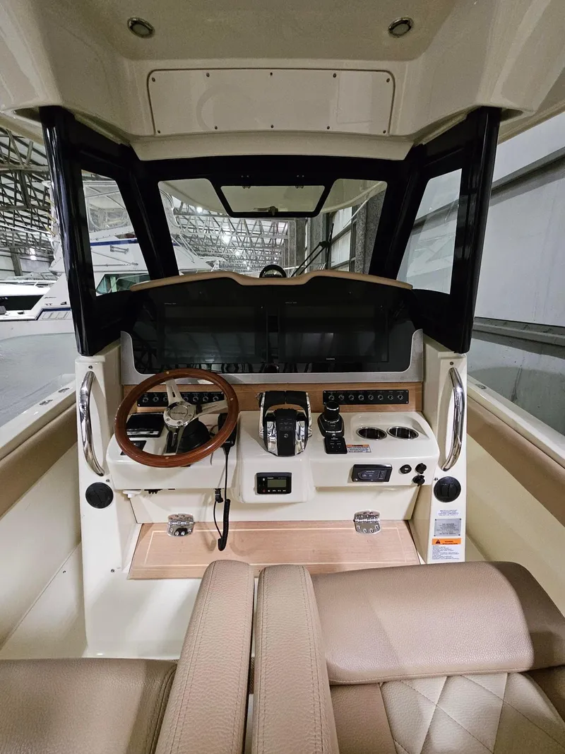 Slide: The Image of 2018 Chris-Craft 30 Catalina helm with steering wheel, controls, and navigation equipment. - 16