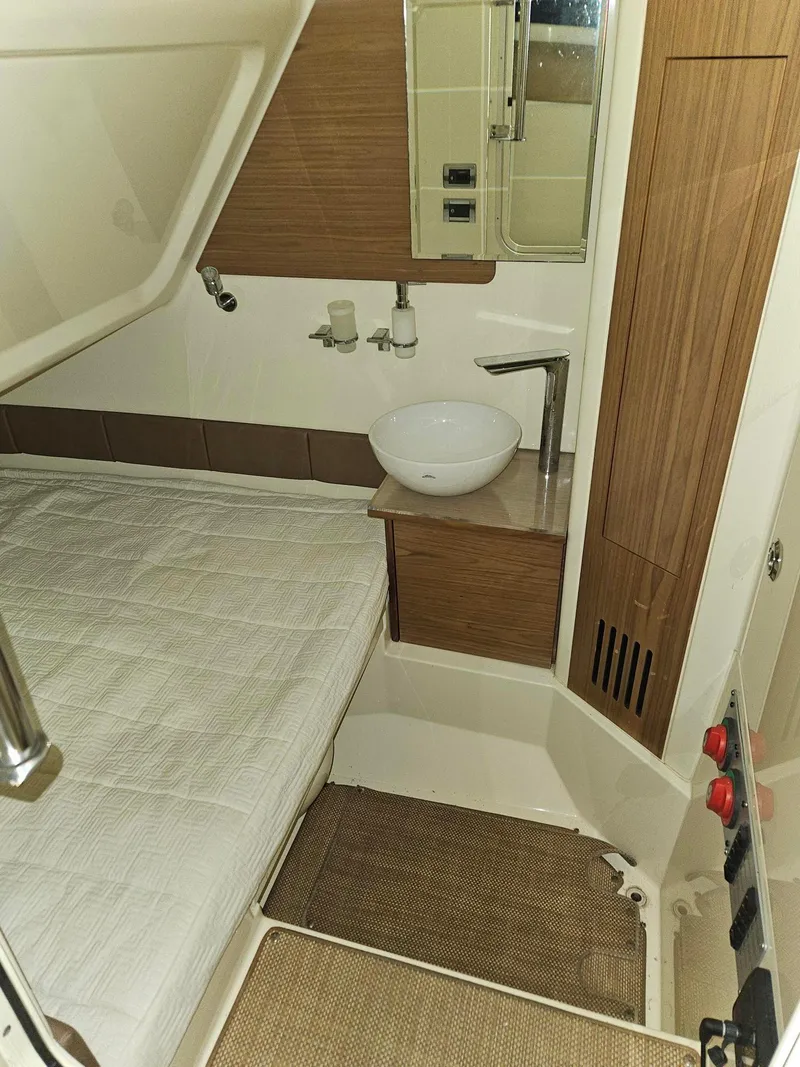 Slide: The Image of 2018 Chris-Craft 30 Catalina cabin interior with bed, sink, and wooden accents. - 5
