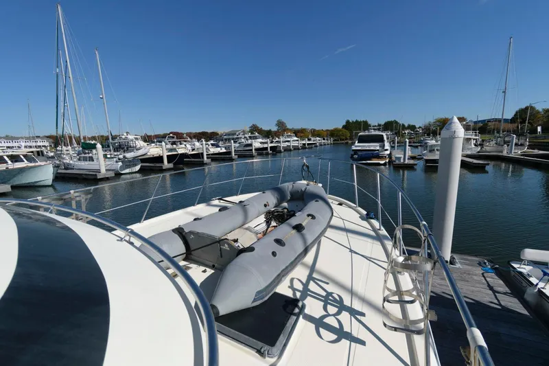 Slide: The Image of 1988 Symbol 55 Cockpit Motor Yacht docked in a marina under clear blue skies. - 11
