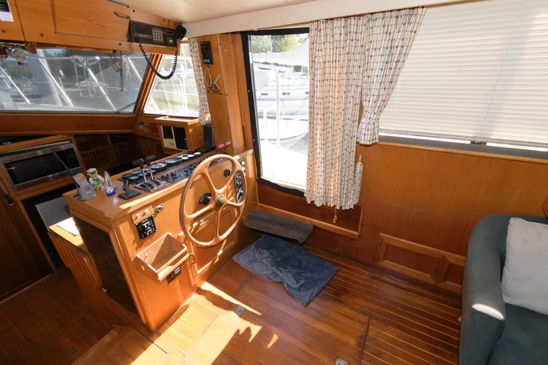 Slide: The Image of 1988 Symbol 55 Cockpit Motor Yacht interior with wooden helm, steering wheel, and nautical controls. - 14