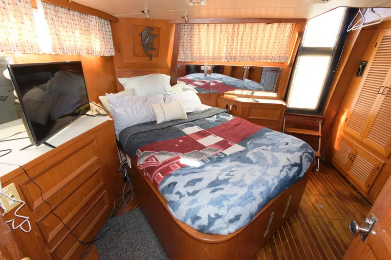 Slide: The Image of Cozy bedroom in 1988 Symbol 55 Cockpit Motor Yacht with wood accents and TV. - 18