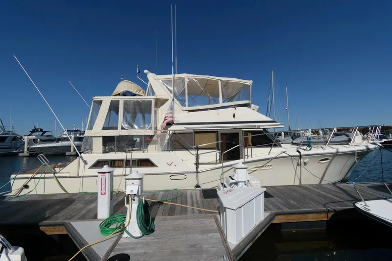 Slide: The Image of 1988 Symbol 55 Cockpit Motor Yacht docked at marina under clear blue sky. - 2