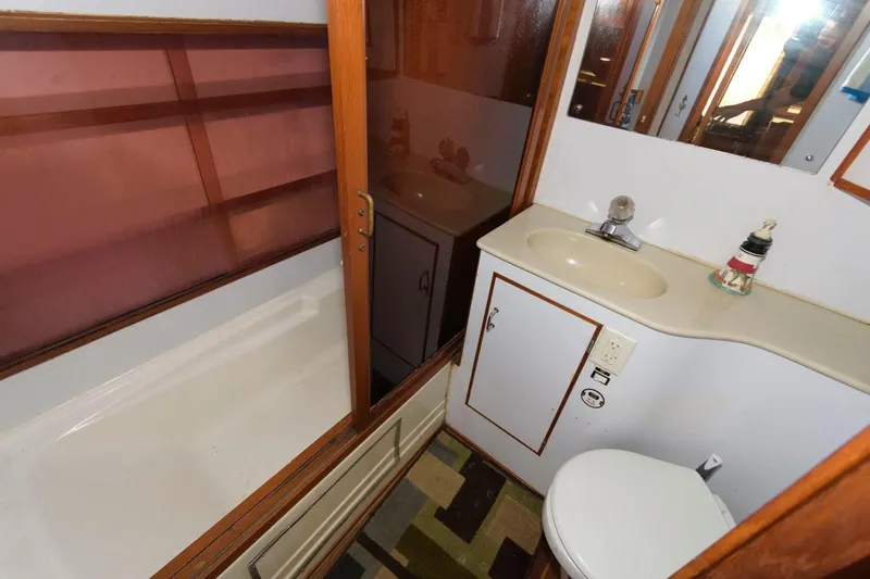 Slide: The Image of 1988 Symbol 55 Cockpit Motor Yacht bathroom with sink, toilet, and shower. - 21