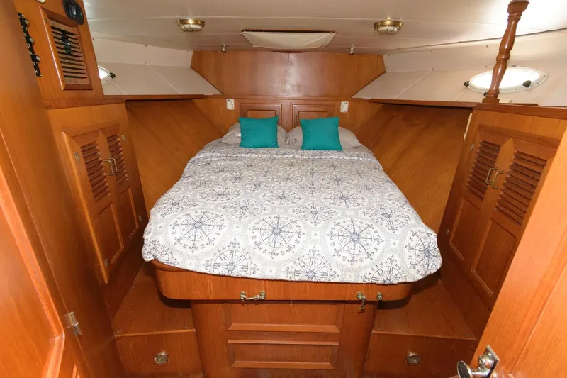 Slide: The Image of 1988 Symbol 55 Cockpit Motor Yacht bedroom with wooden interior and cozy bedding. - 22