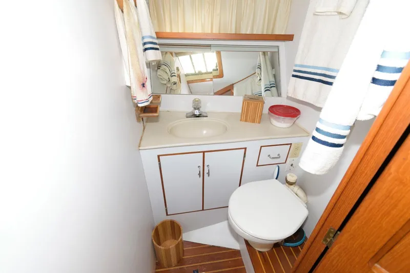 Slide: The Image of Compact bathroom in 1988 Symbol 55 Cockpit Motor Yacht with sink, mirror, and toilet. - 23