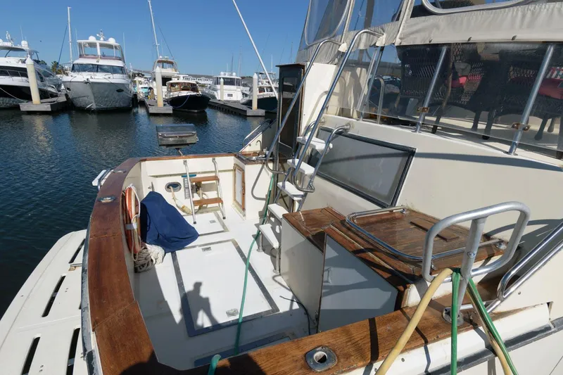 Slide: The Image of 1988 Symbol 55 Cockpit Motor Yacht docked at marina, showcasing spacious deck and seating area. - 3