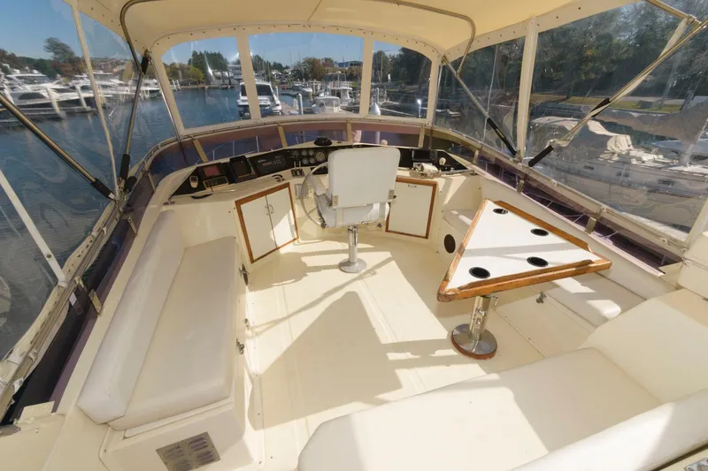 Slide: The Image of 1988 Symbol 55 Cockpit Motor Yacht interior with helm, seating, and triangular table. - 5