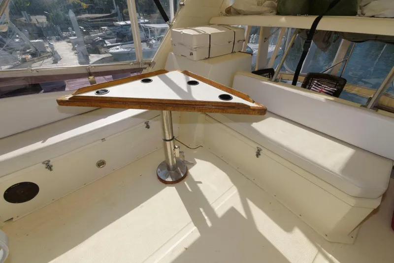 Slide: The Image of 1988 Symbol 55 Cockpit Motor Yacht interior with triangular table and cushioned seating. - 6