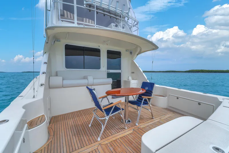 Slide: The Image of 2008 Riviera 51 Enclosed Bridge yacht with deck chairs and table on open sea. - 13