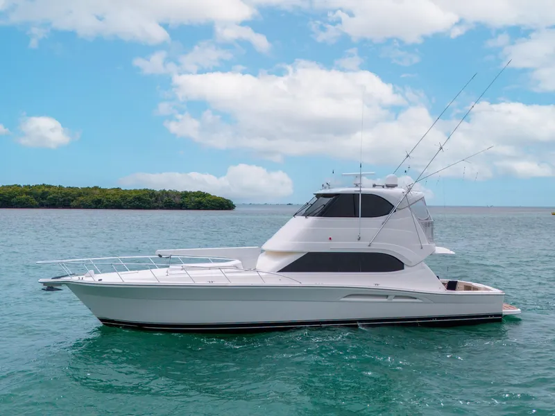 Slide: The Image of 2008 Riviera 51 Enclosed Bridge yacht on calm water under a blue sky. - 2