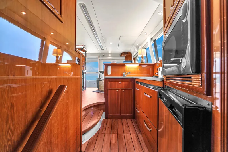 Slide: The Image of Luxurious 2008 Riviera 51 Enclosed Bridge yacht interior with wooden cabinetry and modern appliances. - 32