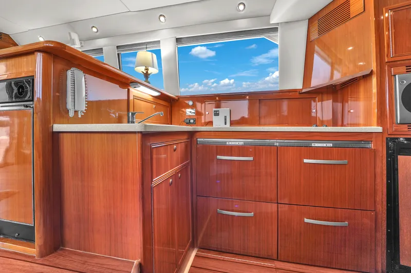 Slide: The Image of Luxurious 2008 Riviera 51 Enclosed Bridge yacht interior with polished wood cabinetry and modern amenities. - 34