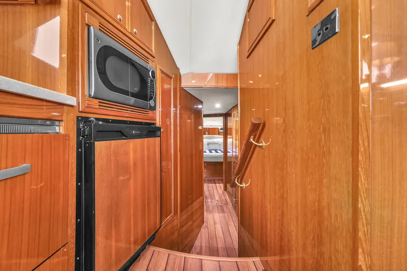 Slide: The Image of Interior of 2008 Riviera 51 Enclosed Bridge yacht with wood paneling and kitchen appliances. - 35