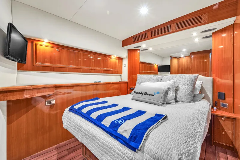 Slide: The Image of Luxurious bedroom interior of 2008 Riviera 51 Enclosed Bridge yacht with wood paneling and cozy bedding. - 36