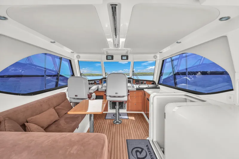 Slide: The Image of Interior of 2008 Riviera 51 Enclosed Bridge yacht with helm and seating area. - 45