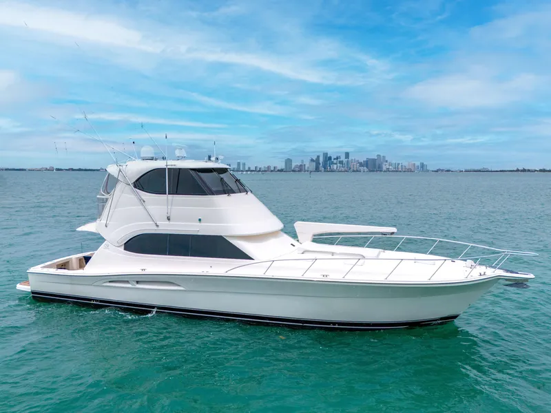 Slide: The Image of 2008 Riviera 51 Enclosed Bridge yacht on blue water with city skyline background. - 5