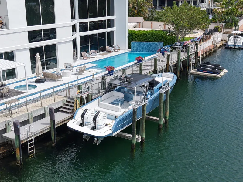 Slide: The Image of 2023 Limitless Seas 45 XLV yacht docked by a luxurious waterfront property. - 4