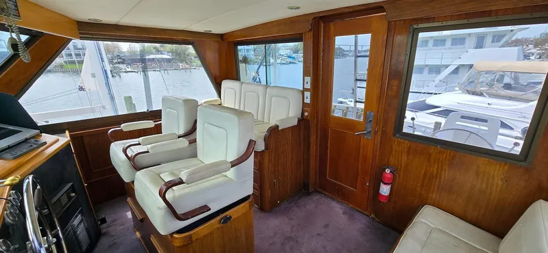 Slide: The Image of Interior of 1979 Hatteras 60 Enclosed Bridge Convertible with plush seating and wood paneling. - 18