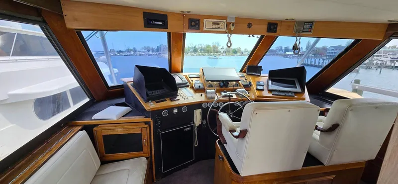 Slide: The Image of 1979 Hatteras 60 Enclosed Bridge Convertible helm with panoramic windows and modern navigation equipment. - 20