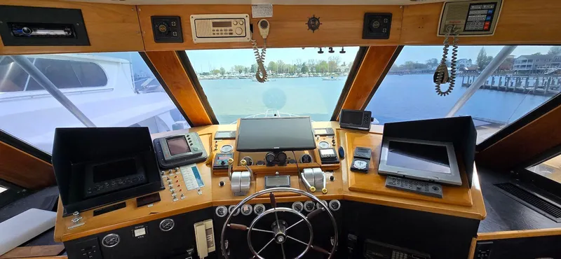 Slide: The Image of 1979 Hatteras 60 Enclosed Bridge Convertible helm with navigation equipment and panoramic windows. - 21