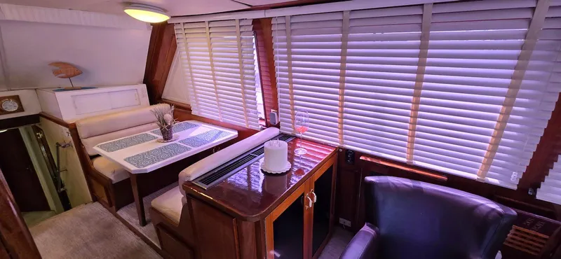 Slide: The Image of Interior of 1979 Hatteras 60 Enclosed Bridge Convertible yacht with dining area and blinds. - 24