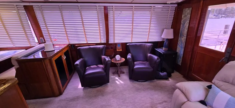 Slide: The Image of Interior of 1979 Hatteras 60 Enclosed Bridge Convertible with leather chairs and wood paneling. - 25