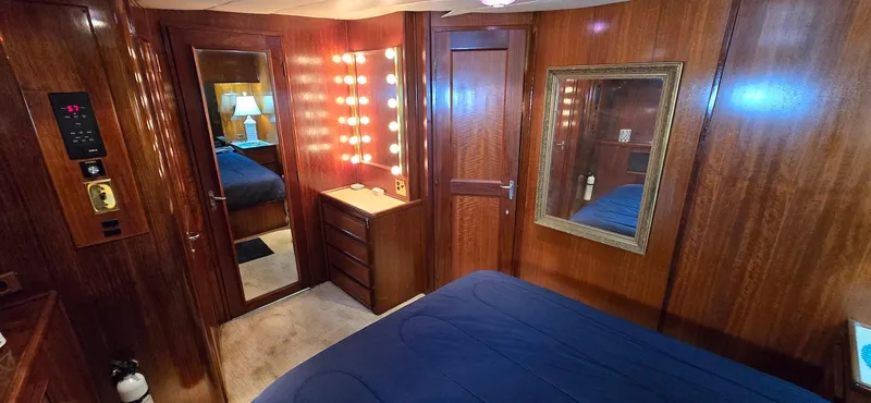 Slide: The Image of 1979 Hatteras 60 Enclosed Bridge Convertible yacht cabin with wood paneling and vanity lights. - 32